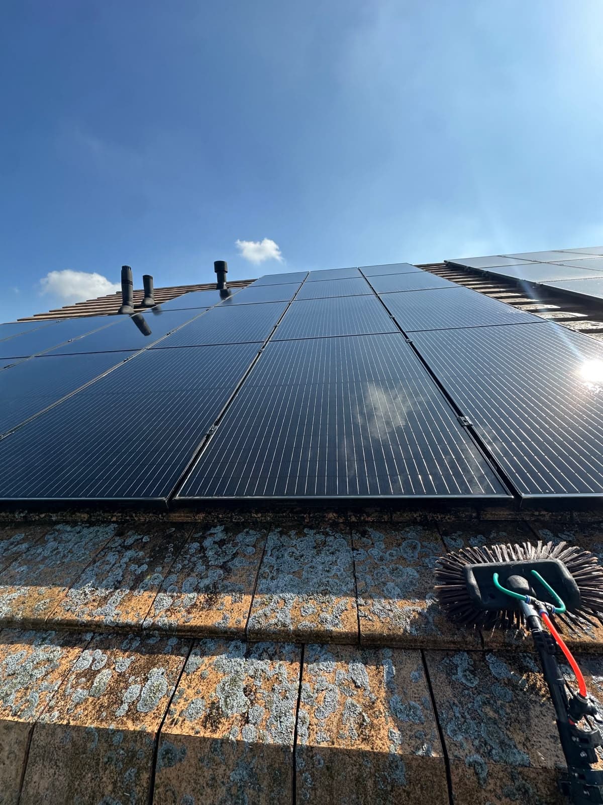 Zonnepanelen op een schuin dak tijdens professionele reiniging